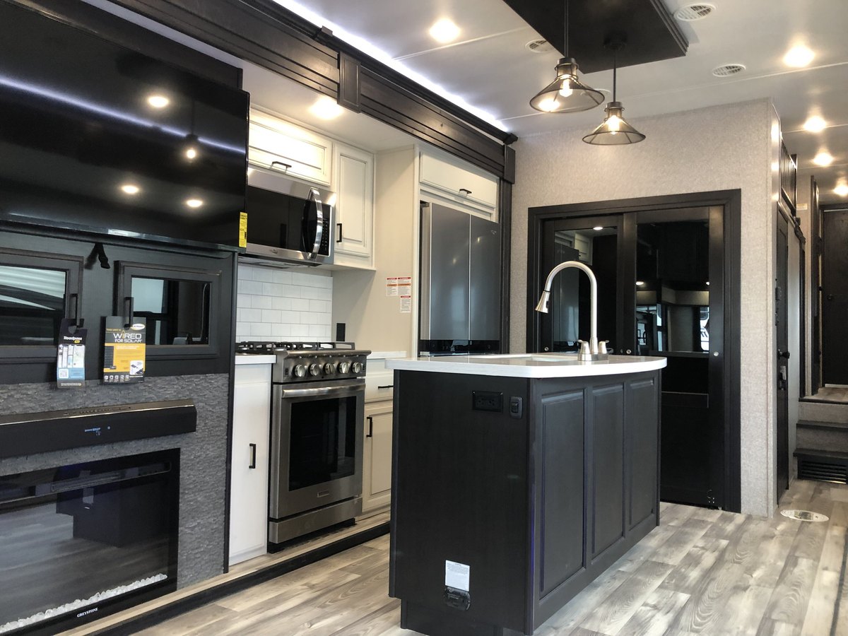 The fully equipped kitchen with an island and full-size appliances inside the eight-person rental RV at In The Pines
