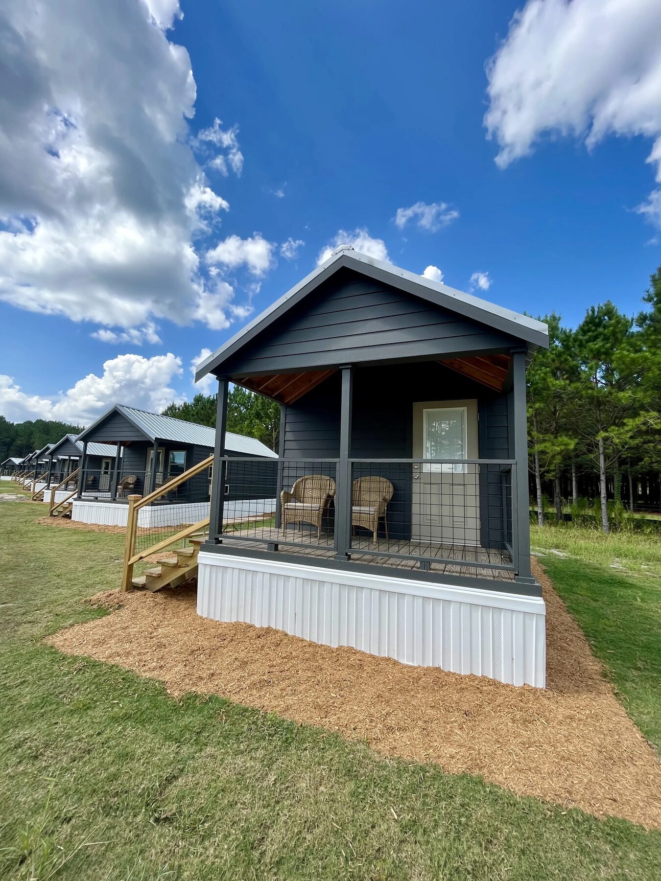 A cabin porch with rocking chairs looking onto the common green