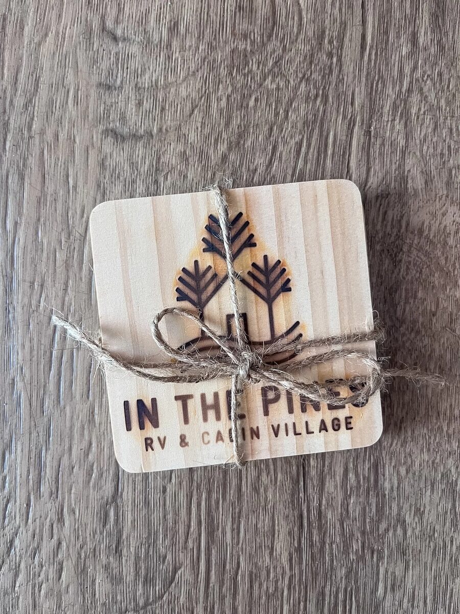 A set of two engraved In The Pines wood coasters