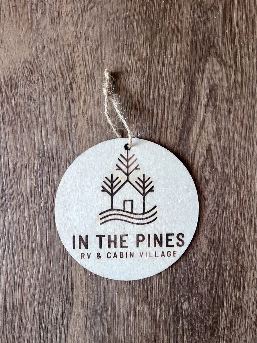 An engraved In The Pines wood ornament